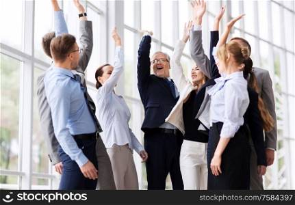 corporate and teamwork concept - happy business team making high five or celebrating success at office. business people celebrating success at office