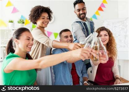 corporate, celebration and holidays concept - happy team clinking bottles with non-alcoholic drinks at office party. happy team with drinks celebrating at office party