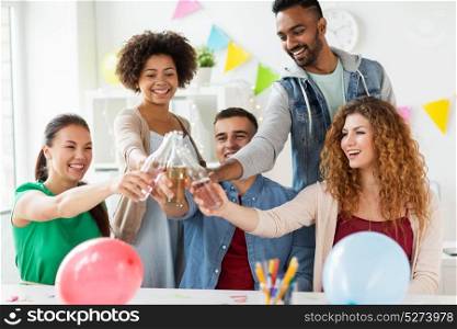 corporate, celebration and holidays concept - happy team clinking bottles with non-alcoholic drinks at office party. happy team with drinks celebrating at office party