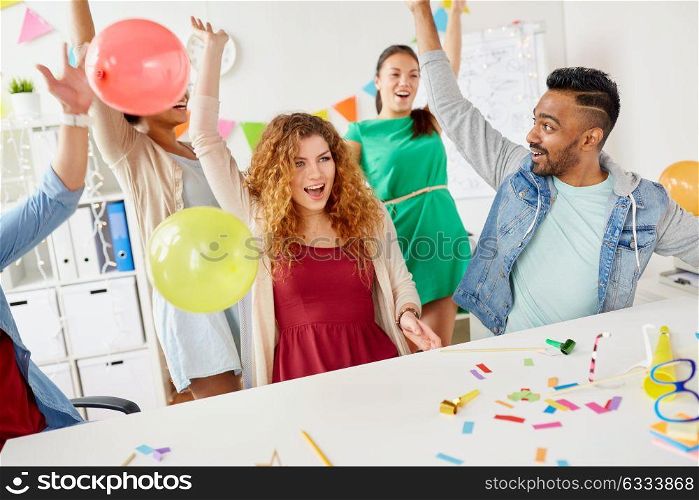 corporate, celebration and holidays concept - happy team with confetti and serpentine having fun at office party. happy team having fun at office party