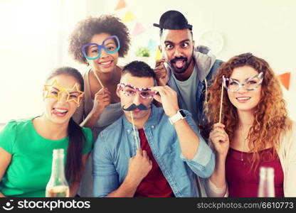 corporate, celebration and holidays concept - happy team with party accessories having fun at office. happy team having fun at office party