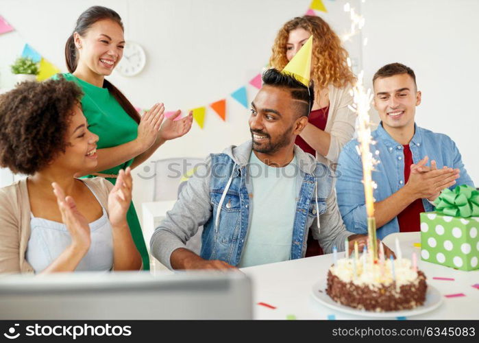 corporate, celebration and people concept - happy business team with birthday cake and gifts greeting male colleague at office party. office team greeting colleague at birthday party