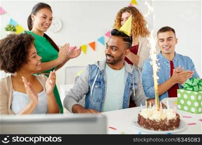 corporate, celebration and people concept - happy business team with birthday cake and gifts greeting male colleague at office party. office team greeting colleague at birthday party