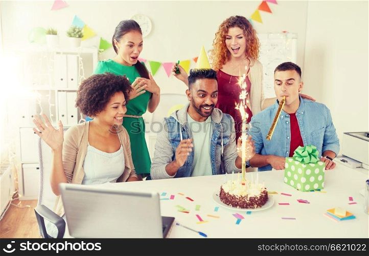 corporate, celebration and people concept - happy business team with birthday cake and gifts greeting male colleague at office party. office team greeting colleague at birthday party