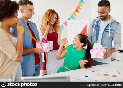 corporate, celebration and people concept - happy team with gifts greeting female colleague at office birthday party. team greeting colleague at office birthday party