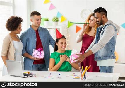corporate, celebration and people concept - happy team with gifts greeting surprised colleague at office birthday party. team greeting colleague at office birthday party