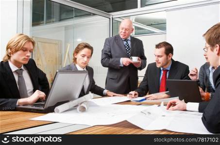 Corporate design team meeting to discuss architectural blueprints