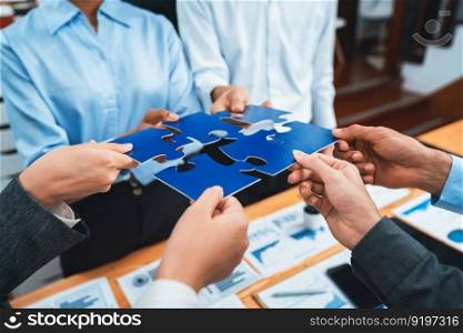 Corporate officer worker collaborate in office, connecting puzzle pieces with report paper on table as partnership and teamwork. Unity and synergy in business concept by merging jigsaw puzzle. Concord. Corporate officer workers connecting puzzle pieces on table. Concord