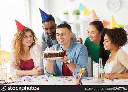 corporate party and people concept - happy team with cake and non-alcoholic drinks celebrating colleague 21st birthday at office party. man with birthday cake and team at office party