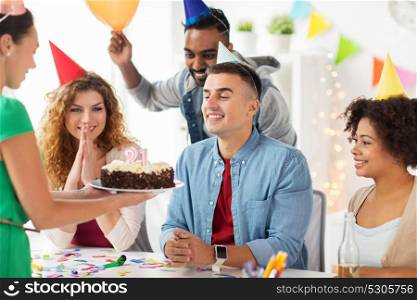 corporate party and people concept - happy team with cake and non-alcoholic drinks celebrating colleague 21st birthday at office party. team greeting colleague at office birthday party