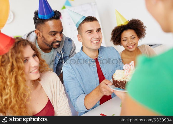 corporate party and people concept - happy team with cake and non-alcoholic drinks celebrating colleague 21st birthday at office. team greeting colleague at office birthday party