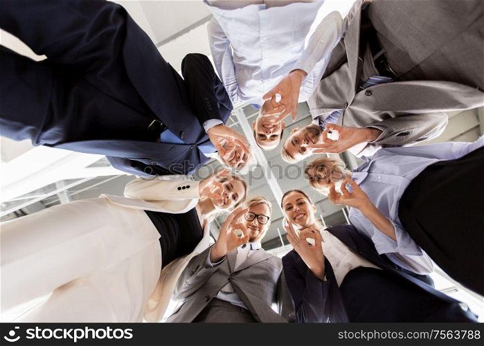 corporate, people and teamwork concept - business team showing ok hand sign at office from below. business people showing ok hand sign at office