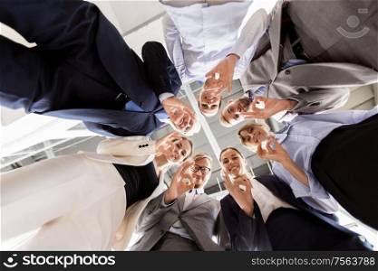 corporate, people and teamwork concept - business team showing ok hand sign at office from below. business people showing ok hand sign at office