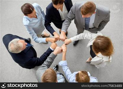 corporate, people and teamwork concept - happy business team making fist bump. happy business people making fist bump