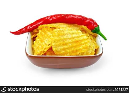 Corrugated potato chips in a clay bowl with fresh red chili peppers isolated on white background