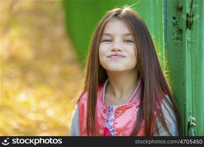Cose up, Beautiful little girl on green background of summer city park