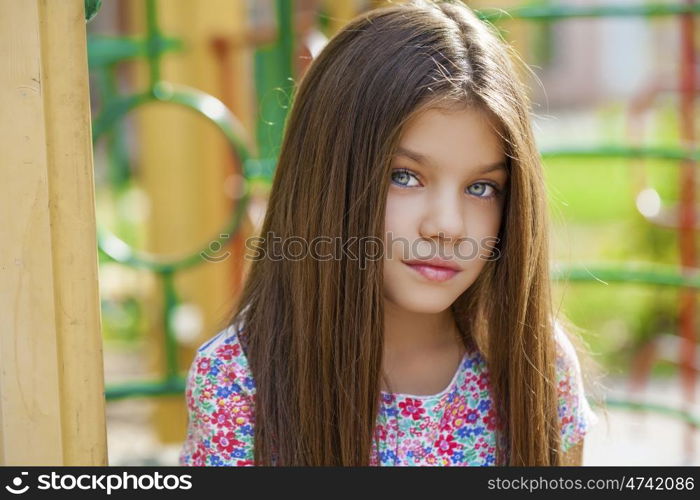 Cose up, Beautiful little girl on green background of summer city park