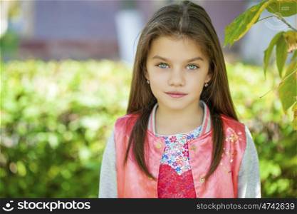 Cose up, Beautiful little girl on green background of summer city park