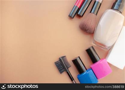 Cosmetic accessories. Brush, blush, lipstick, cream, nail polish on a yellow, cream background. With empty space below. View from above. Cosmetic accessories. Brush, blush, lipstick, cream, nail polish on a yellow, cream background.