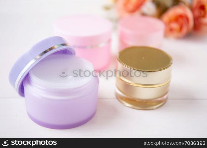 cosmetic and skin care product and flower on white wood table, beauty with treatment cream and moisturizing on wooden desk, health and wellness concept.