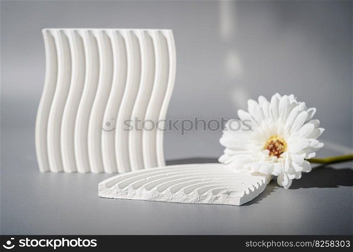Cosmetic background for product presentation. White empty plaster podium with shadows on gray background. Background for product presentation.