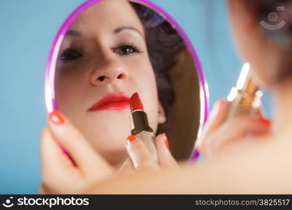 Cosmetic beauty procedures and makeover concept. Closeup part of woman face. Girllooking at mirror applying red lipstick lips makeup