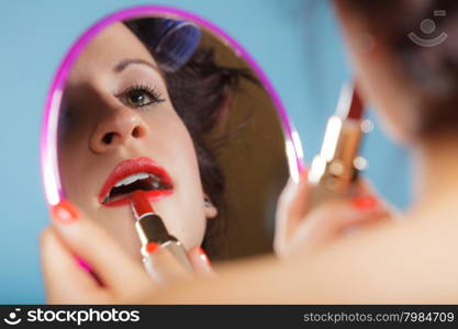 Cosmetic beauty procedures and makeover concept. Closeup part of woman face. Girllooking at mirror applying red lipstick lips makeup