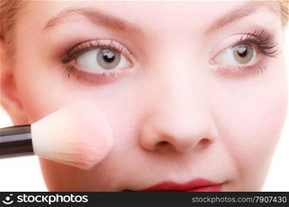 Cosmetic beauty procedures and makeover concept. Closeup part of woman face makeup detail. Applying rouge blusher with brush