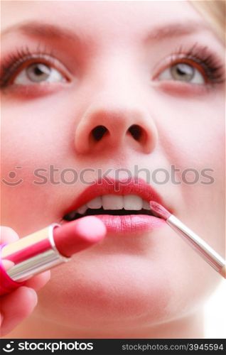 Cosmetic beauty procedures and makeover concept. Closeup part of woman face red lips. Make-up artist applying lipstick with accessories tools.