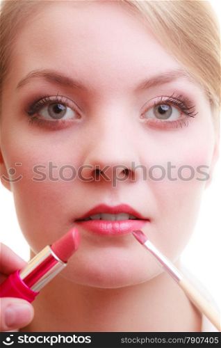 Cosmetic beauty procedures and makeover concept. Closeup part of woman face red lips. Make-up artist applying lipstick with accessories tools.