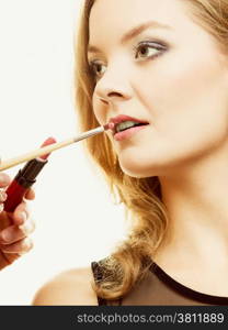 Cosmetic beauty procedures and makeover concept. Makeup artist applying lipstick with accessories tools to woman lips.