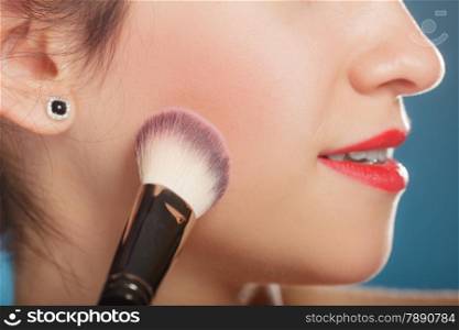 Cosmetic beauty procedures and makeover concept. Woman applying makeup blusher with brush. Girl gets blush on cheekbones closeup part of face