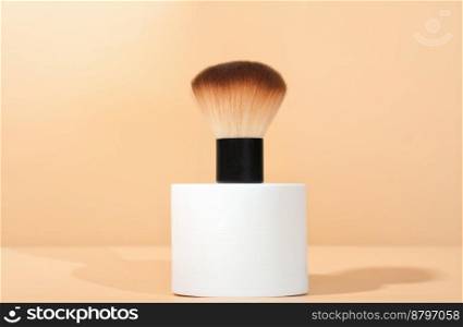 cosmetic brush for powdred or blush application on white geometric podium. cosmetic accessories. make up professional tools. cosmetic brush for powdred or blush application on white geometric podium. cosmetic accessories, make up professional tools.