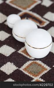 cosmetic containers lying on ethnic mat