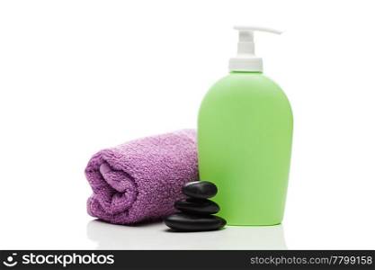 cosmetic containers, towel and black spa stones isolated on white