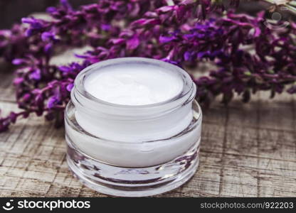 Cosmetic cream and fresh lavender wildflowers on a wooden background. Face cream. Body care.. Cosmetic cream and fresh lavender wildflowers on a wooden background. Face cream.