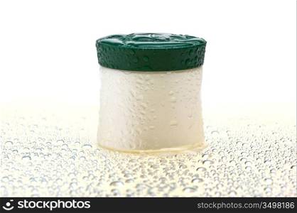 cosmetic cream jar wet isolated on a white background