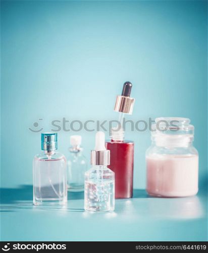 Cosmetic in bottle containers. Skin care setting with toner, essence,serum and cream on turquoise blue background , front view. Beauty product concept. Blank label for branding mock-up