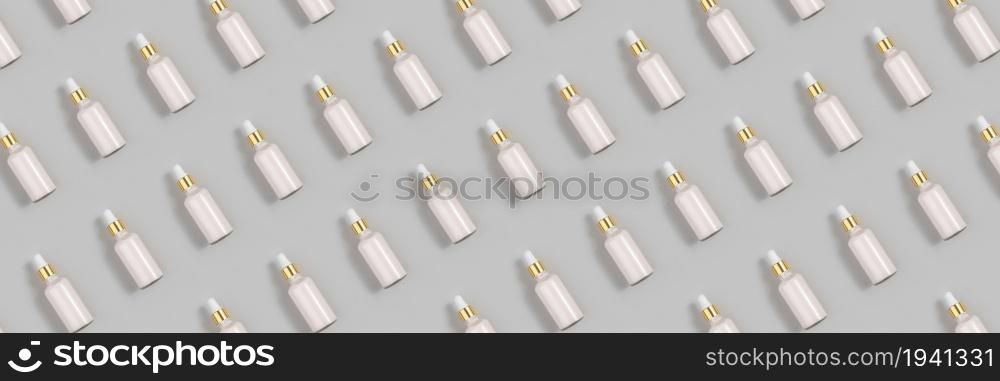 Cosmetic pattern. Banner made with pink anti-aging collagen, facial serum in transparent glass bottle with gold pipette on grey background. Natural Organic Spa Cosmetic Beauty Concept.. Cosmetic pattern. Banner made with pink anti-aging collagen, facial serum in transparent glass bottle with gold pipette on grey background. Natural Organic Spa Cosmetic Beauty Concept