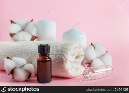 Cosmetic products for spa and aromatherapy. Candles, sea salt, towel and flowers on a pink background. Skin care and beauty concept. Place for your text.. Cosmetic products for spa and aromatherapy. Candles, sea salt, towel and flowers on a pink background. Skin care and beauty concept.