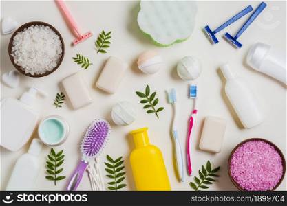 cosmetic products with salt toothbrush razor hairbrush leaves white backdrop. Resolution and high quality beautiful photo. cosmetic products with salt toothbrush razor hairbrush leaves white backdrop. High quality beautiful photo concept