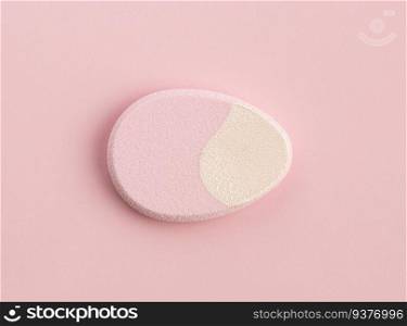 Cosmetic sponge in the shape of an egg on a pink background. Top view. The cosmetic sponge in the shape of an egg on a pink background. Top view