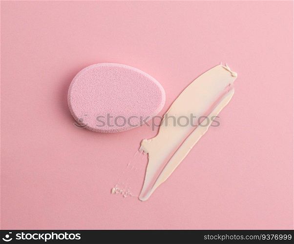 Cosmetic sponge in the shape of an egg on a pink background. Top view. The cosmetic sponge in the shape of an egg on a pink background. Top view
