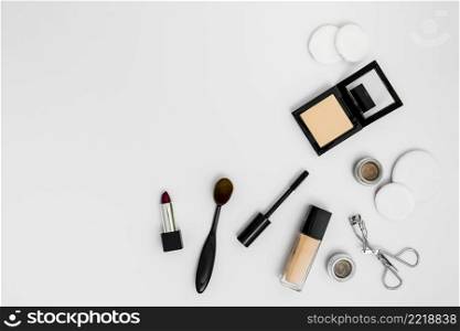 cosmetic sponges compact powder foundation lipstick eyeshadow eyelash curler brushes white background