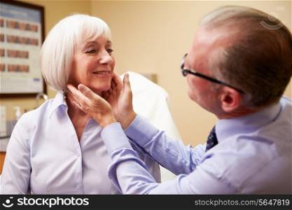 Cosmetic Surgeon Examining Senior Female Client In Office