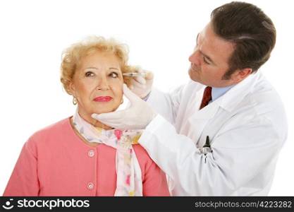 Cosmetic surgeon injecting a senior woman&rsquo;s face to fill in wrinkles. Isolated on white.