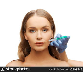 cosmetic surgery concept - woman face and beautician hand with syringe