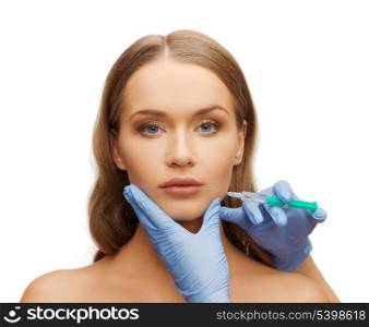 cosmetic surgery concept - woman face and beautician hands with syringe