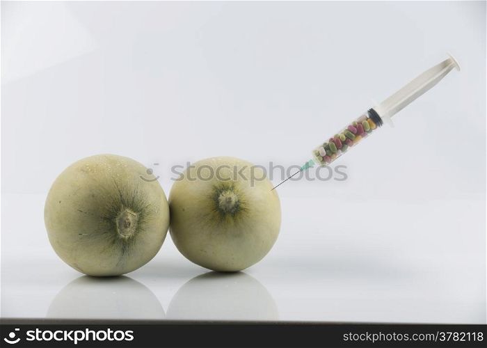 Cosmetic treatment for Female breasts metaphor: melons and syringe with pills meaning cosmetic and health treatment