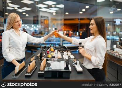 Cosmetician at the counter and woman in cosmetics store. Luxury beauty shop salon, female customer and beautician in fashion store. Cosmetician at counter and woman, cosmetics store